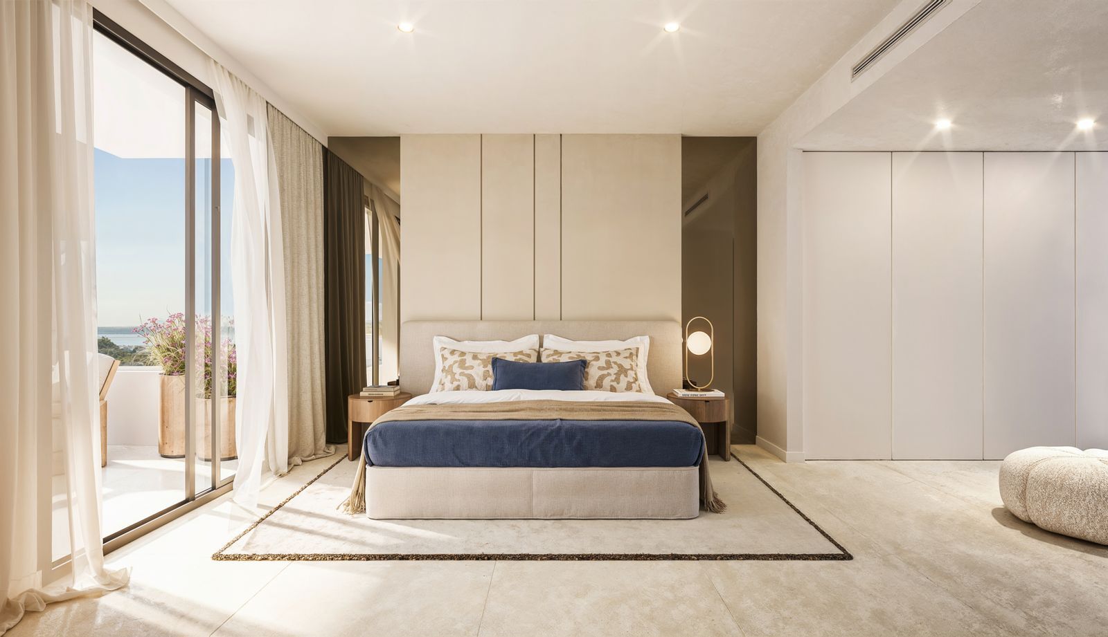 Modern bedroom with ocean view, large bed, and floor-to-ceiling windows.